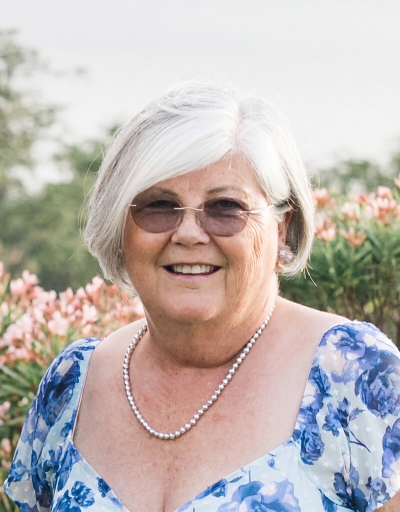 Andrea Easley smiling among pink flowers