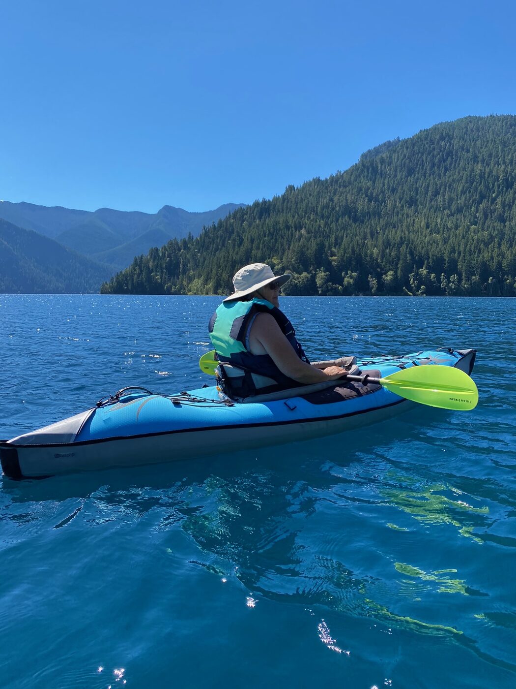 Andrea kayaking on a blue mountain lake
