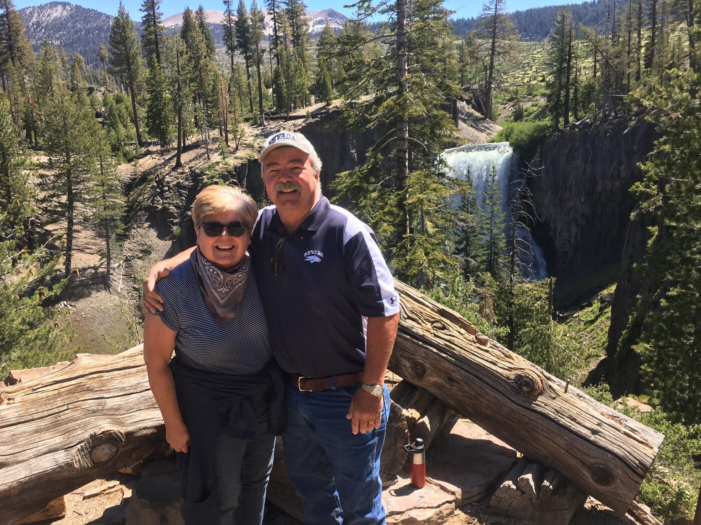 Andrea and Dan in front of a waterfall in the mountains