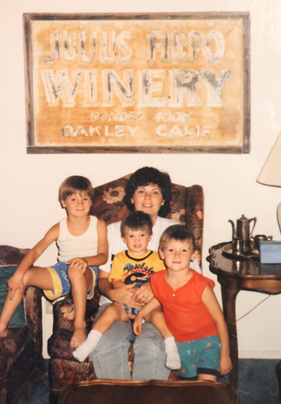 Andrea with her three boys under the Julius Firpo Winery sign in Oakley