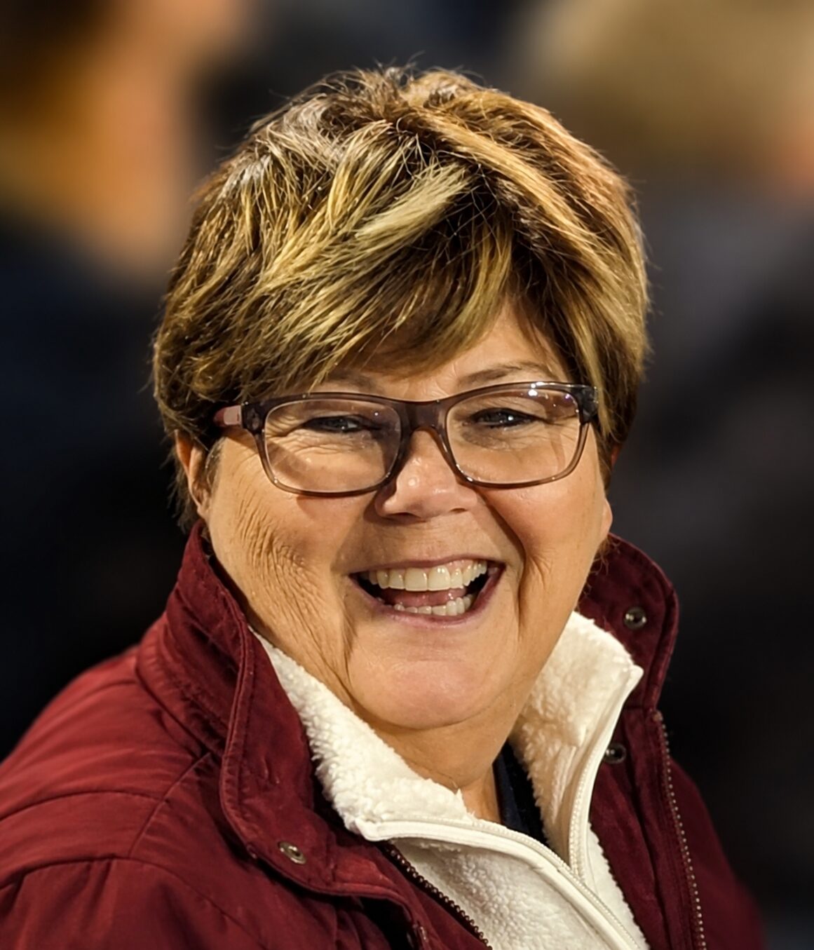 Andrea laughing, wearing a maroon jacket